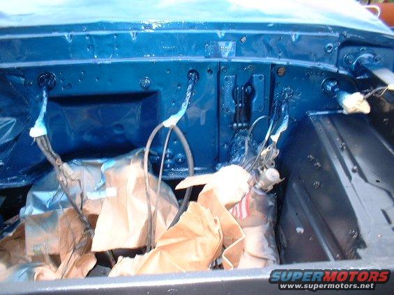 Blue painted engine bay with parts covered in brown paper