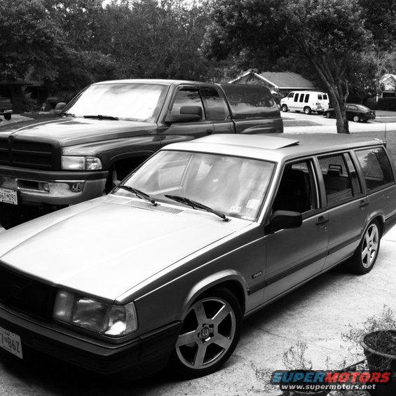 Silver 1991 Volvo 940 wagon, 3q-front view, parked next to a pickup truck