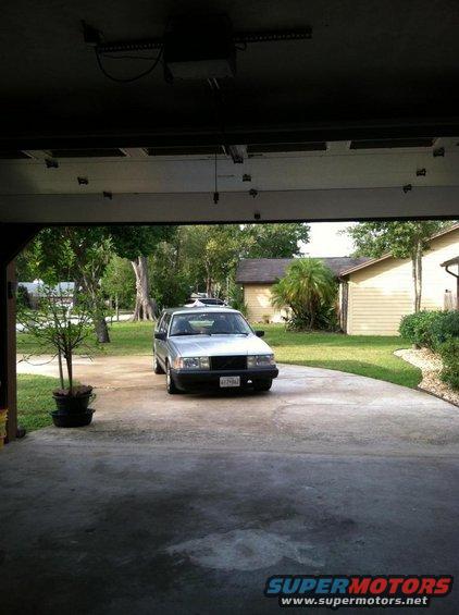 Silver 1991 Volvo 940 sedan parked in driveway, viewed from garage