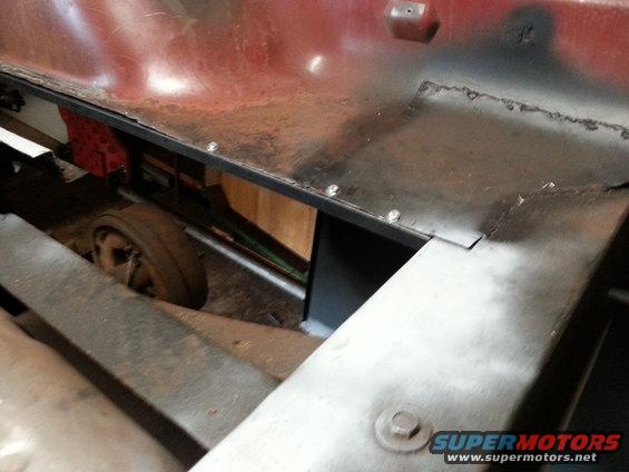 Vehicle underbody with visible wheel and red body panel
