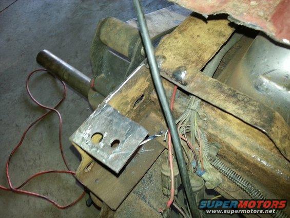 Rusted vehicle frame section with exposed wiring and metal brackets