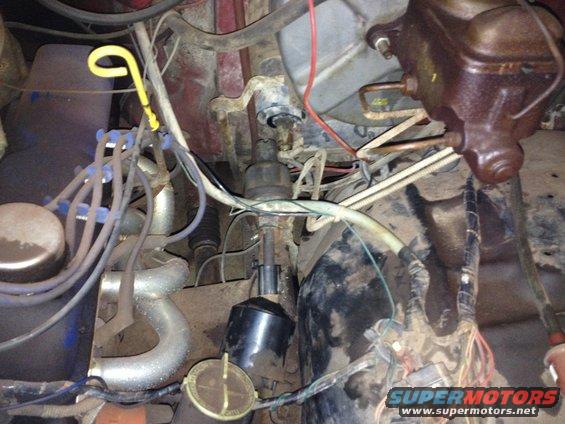 Engine bay with brake fluid reservoir, distributor, spark plug wires, and exhaust manifold