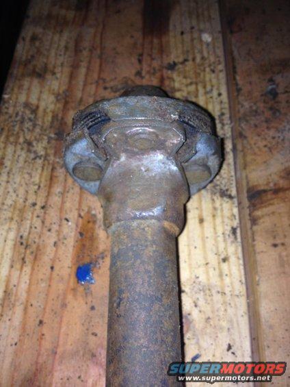 rusted metal shaft with universal joint on wooden surface