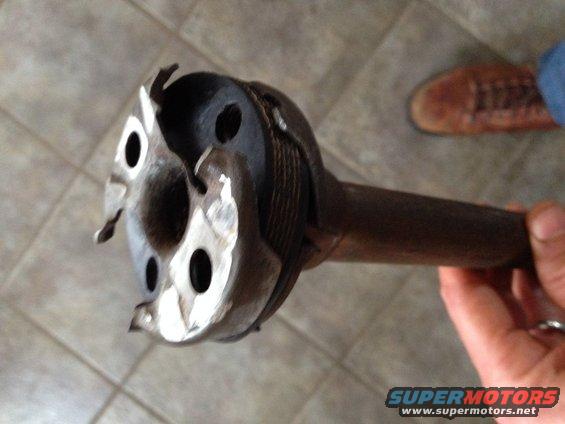 Close-up of a driveshaft U-joint with visible wear and damage