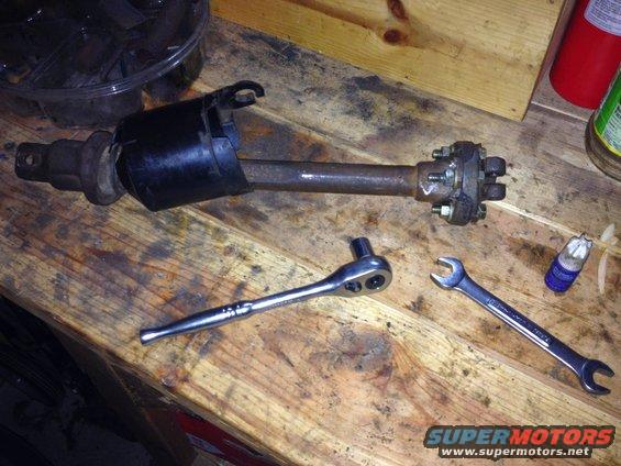 Steering column part with ratchet and wrench on wooden surface