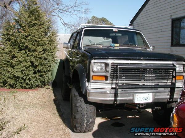 Black Ford Bronco with brush guard and lifted suspension, parked in a driveway