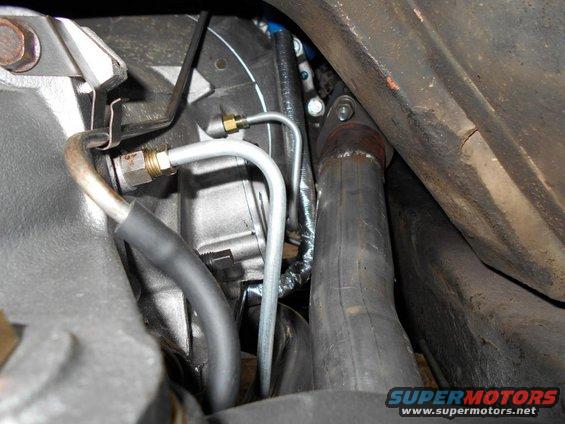 Engine bay detail with exhaust pipe and brake lines