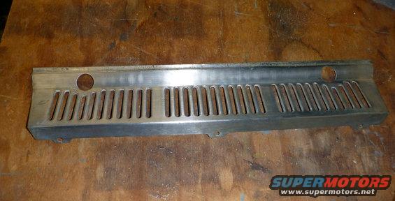 Metal grille with vertical slots and two circular holes