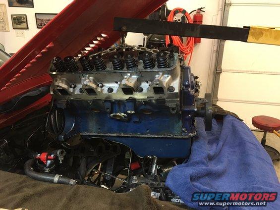 Engine with valve covers removed, being lifted by an engine hoist