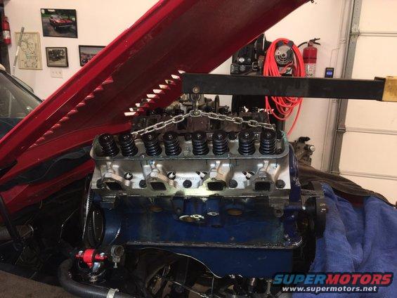 Engine block with valve covers and intake manifold being lifted by an engine hoist