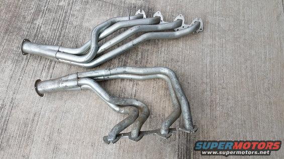 Pair of silver exhaust headers on concrete