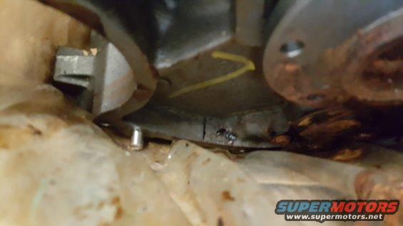Close-up of an engine component with a yellow arrow marking