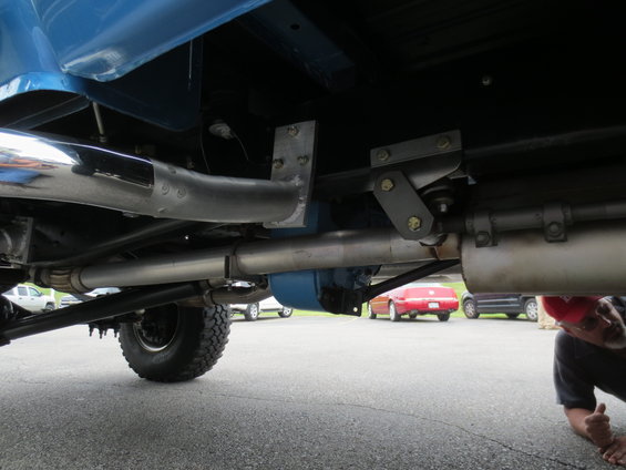 Undercarriage of blue 1967 Ford F-250 showing custom exhaust and suspension components