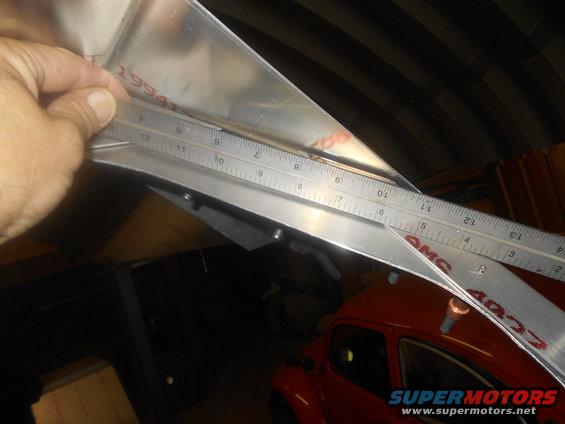 Measuring metal part with ruler, 1994 visible on part