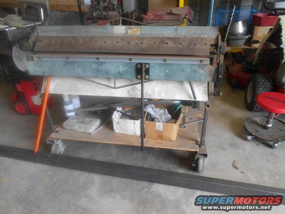 Sheet metal brake on cart with tools and supplies