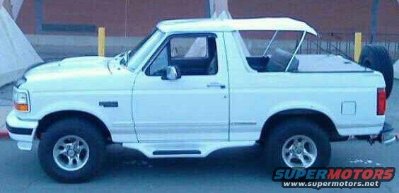 Side view of a white 1995 Ford Bronco with a removable top and spare tire mounted on the back