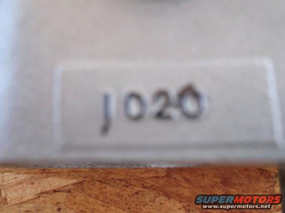 Close-up of a part with embossed numbers 'J020'