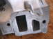 1963 Ford Galaxie - This is a close-up view of a metal engine intake manifold, showing its ports and casting marks.