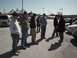 1999 Ford Taurus - A group of people stand in a parking lot on a sunny day, with a white van and other vehicles in the background.