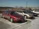 1999 Ford Taurus - Multiple Ford Taurus sedans are parked in a lot under a clear sky.