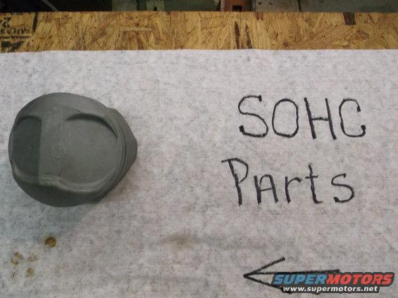 SOHC parts written next to a piston on a white cloth
