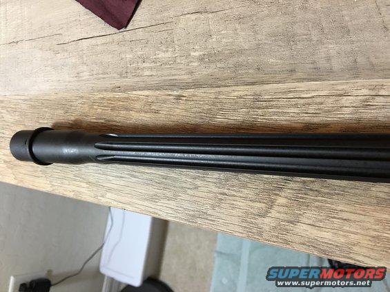 Black fluted barrel with a ring near the end, resting on a wooden surface