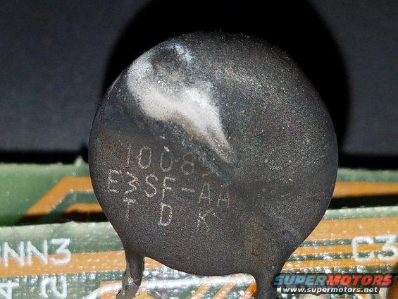 Close-up of a burnt electronic component with markings '1008', 'E3SF-AA', 'TDK' on a circuit board
