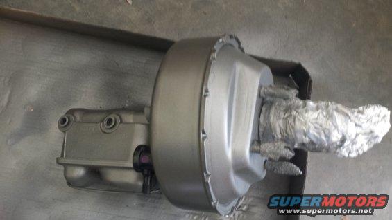 Gray brake booster with foil-wrapped pushrod, angled view