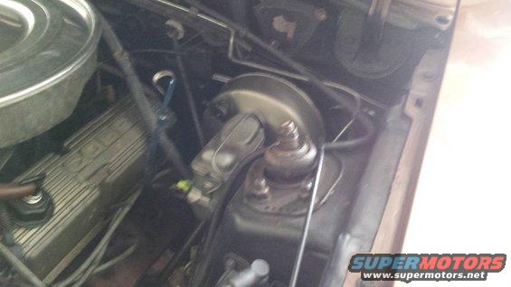engine bay showing brake booster, master cylinder, and part of valve cover