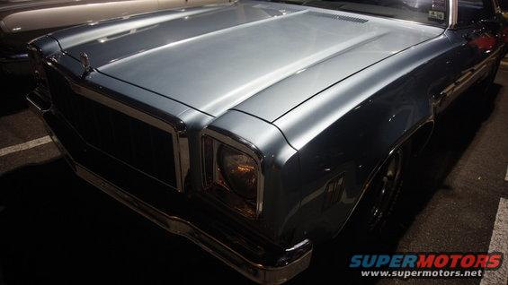 Front corner of a light blue 1970s Chevrolet sedan, showing grille and headlight