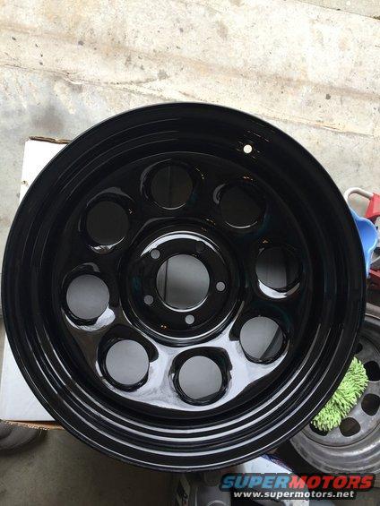 black steel wheel with multiple circular cutouts