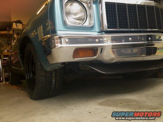 Front end of a light blue classic car, possibly a 1975 Chevrolet Chevelle, with a chrome bumper and grille