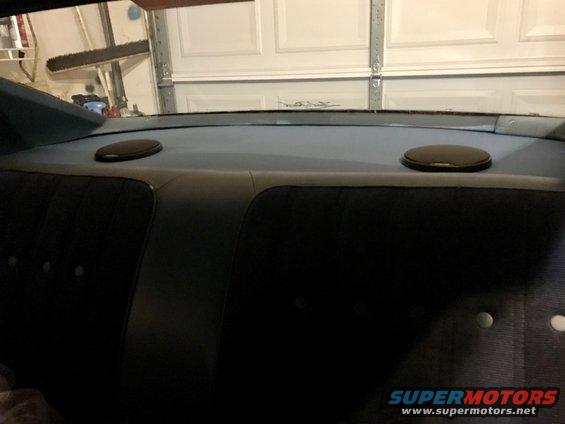 rear car interior showing black seats and two speakers on the rear deck