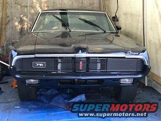 Black 1969 Mercury Cougar front grille with vertical bars, Cougar script on the right, and a red emblem