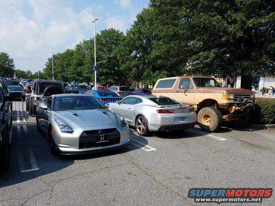 Brown lifted Ford Bronco parked in a lot, front right tire is flat