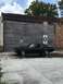 1967 Mercury Cougar - A black 1967 Mercury Cougar is seen from the side, parked in front of a brick building.