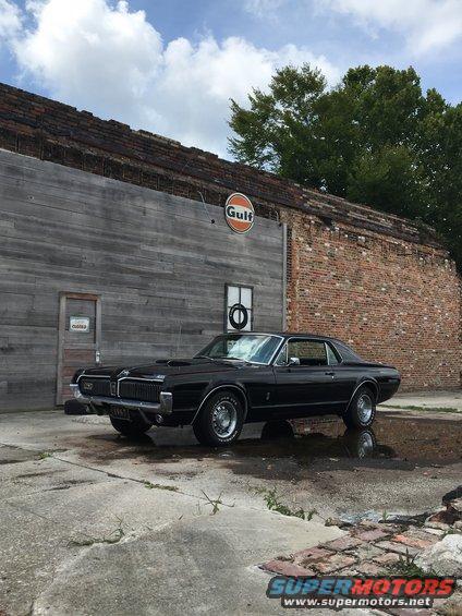 1967 Mercury Cougar parked in front of a brick building with a Gulf sign
