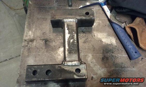 Welded metal part with holes on a workbench