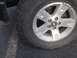 2005 Ford Sport Trac - Close-up of a silver 5-spoke wheel and tire on a dark surface.