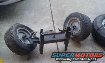 Axle assembly with two wheels and tires, another tire visible to the right