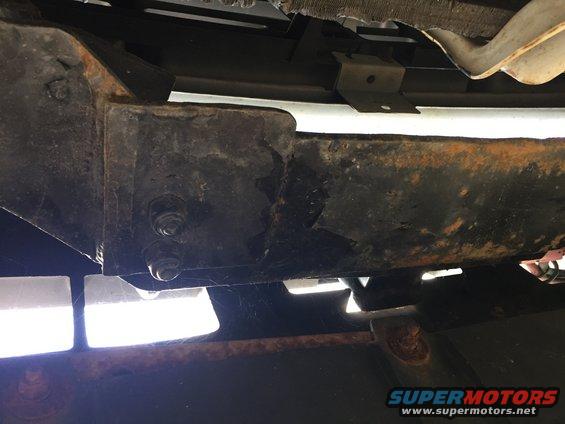 Rusted frame and suspension components with visible bolts and brackets