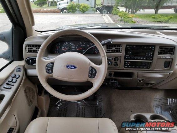 Ford Excursion interior with steering wheel, dashboard, and center console visible. The word EXCURSION is on the dash