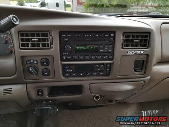 Tan center dash of a Ford Excursion with stacked radio and climate controls