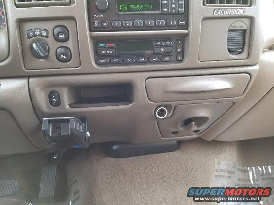 Dashboard of a 2003 Ford Excursion with radio, climate controls, and a trailer brake controller