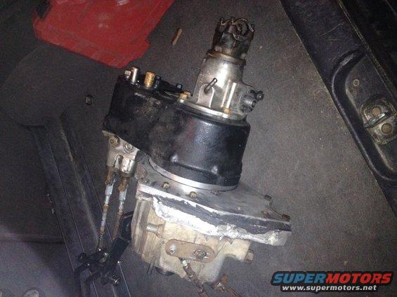 Transfer case assembly with visible gears and housing, likely part of a vehicle drivetrain