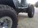 1995 Jeep YJ - Close-up of a 1995 Jeep YJ's side, highlighting its off-road tires and modified rocker panel.