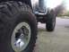 1995 Jeep YJ - A black Jeep YJ is shown from the side, highlighting its large off-road tires and custom wheels.
