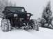 1995 Jeep YJ - A black Jeep Wrangler navigates a snowy landscape with its tires deep in the snow.