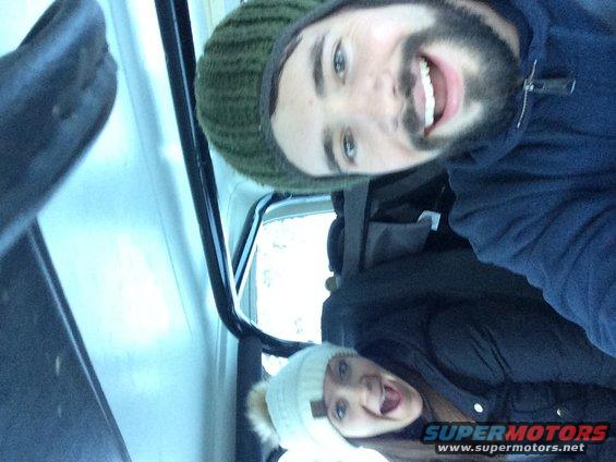 Interior view of a vehicle with two people wearing winter hats
