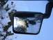 1995 Jeep YJ - Reflection shows a Jeep Wrangler with large tires driving in a snowy environment.